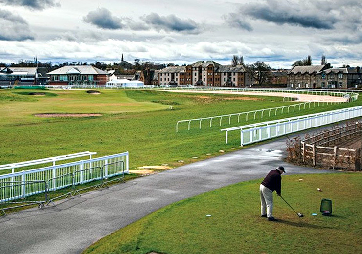 A golfer hits his drive over the horseracing track on the sixth tee box at Musselburgh Golf Links. Photo: Andrew Hetherington