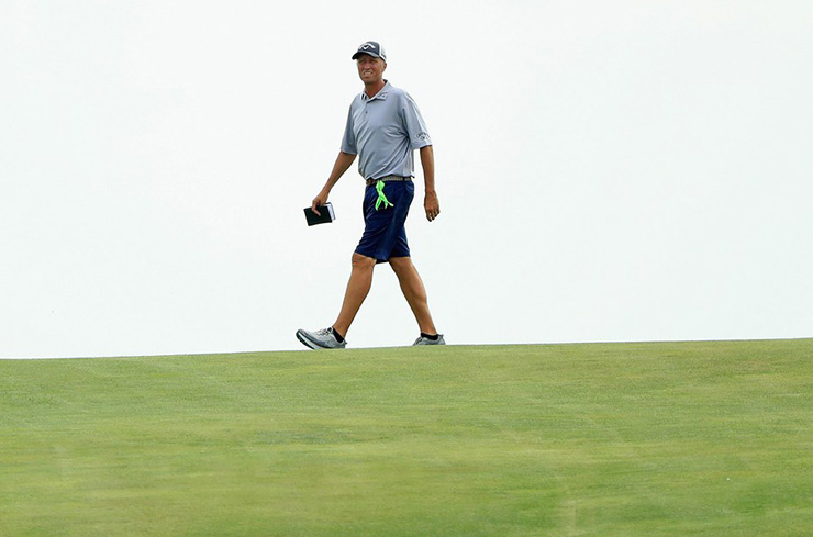 Jim Mackay, caddie for Phil Mickelson, walks across the course during a Wednesday practice round prior to the 2017 U.S. Open. (Photo by Andrew Redington/Getty Images)