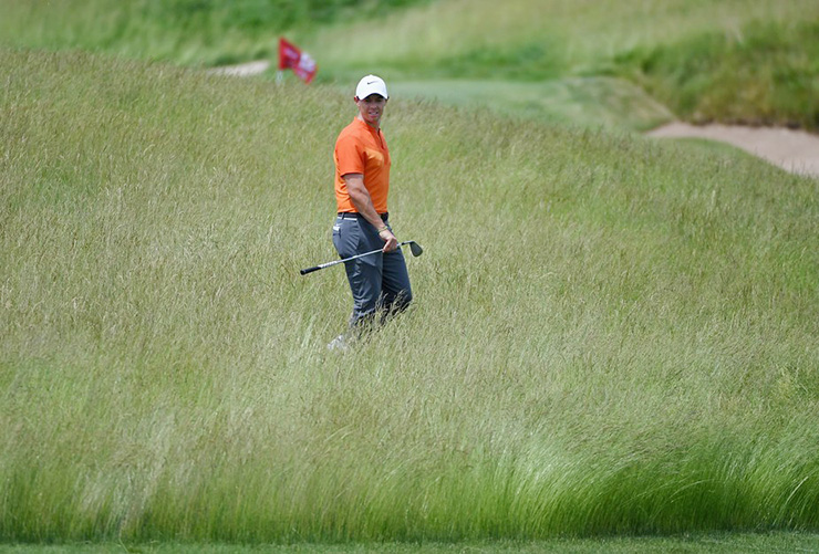 Rory McIlroy strolls through the fescue rough at Erin Hills during Wednesday’s practice round. (Photo by Ross Kinnaird/Getty Images)