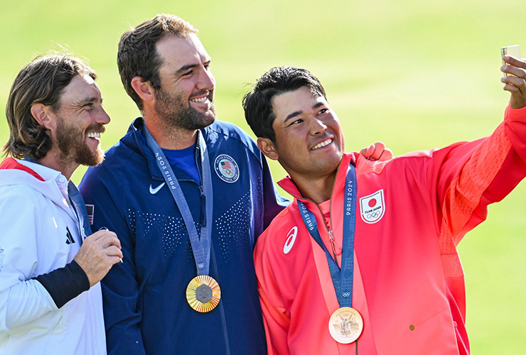 Gold medal winner Scottie Scheffler poses for a selfie with Japan bronze medalist Hideki Matsuyama and Great Britian silver medalist Tommy Fleetwood - Keyur Khamar